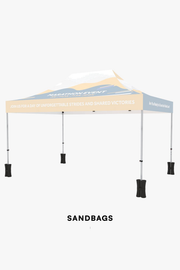 Sand bags anchoring the four legs of the 10x15 canopy tent